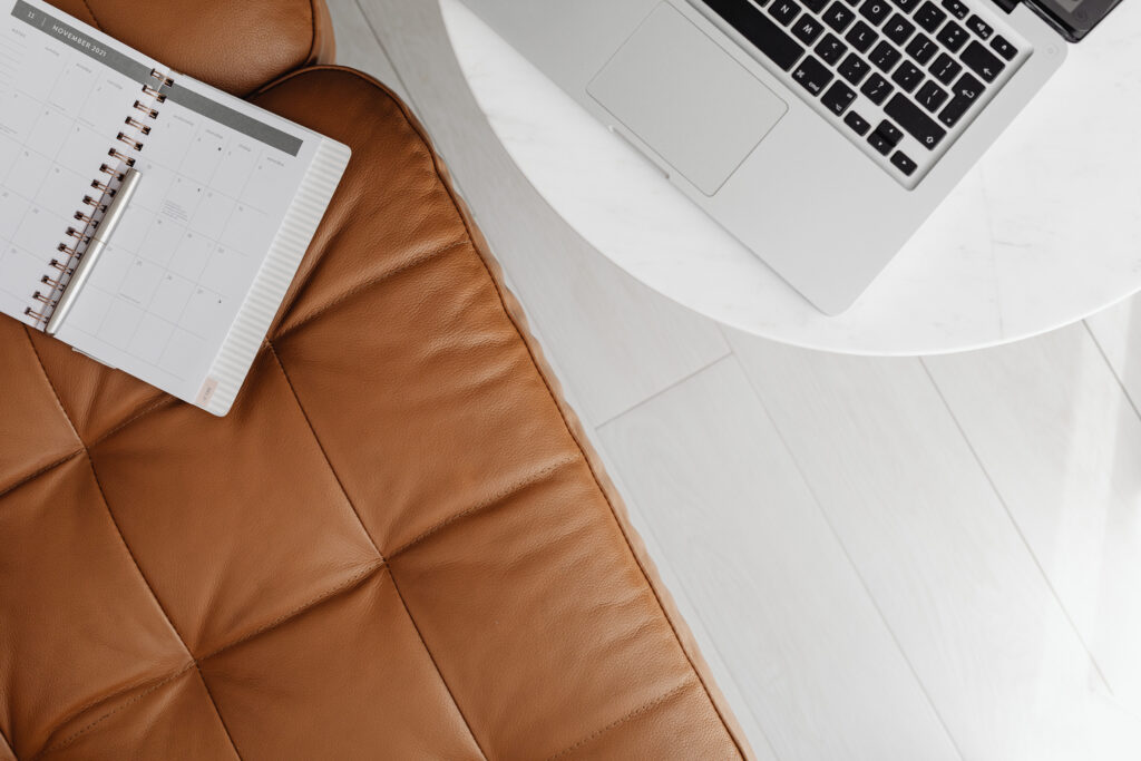 Planner and laptop on a couch.